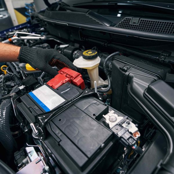 person-checking-the-car-battery-under-bonnet-2023-11-27-05-16-34-utc-min